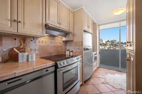 a kitchen with stainless steel appliances granite countertop a refrigerator and a stove