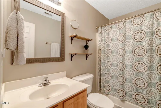 a bathroom with a toilet sink shower and mirror