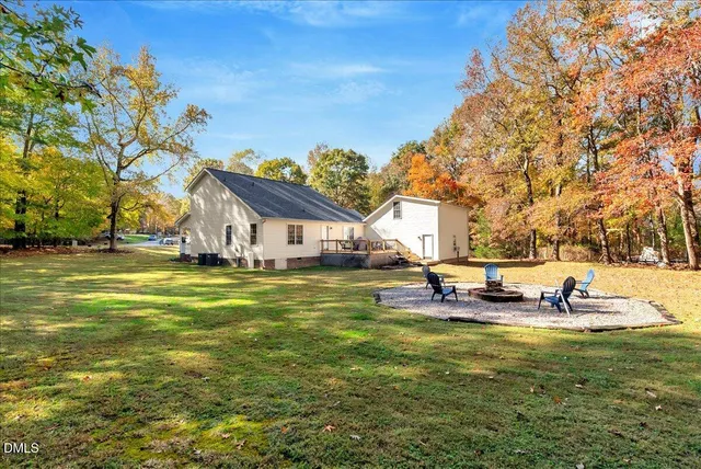a view of a swimming pool with lawn chairs and a big yard