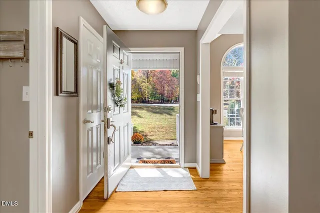 a view of a hallway with wooden floor and windows