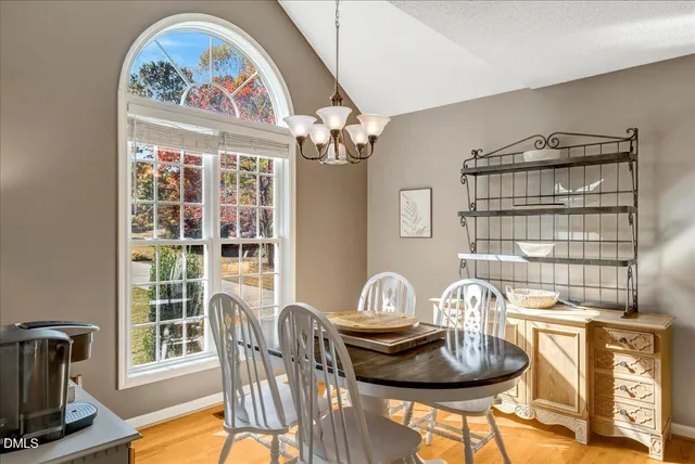 a view of a dining room with furniture a chandelier and wooden floor