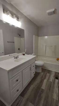 a bathroom with double vanity sink a mirror and a toilet