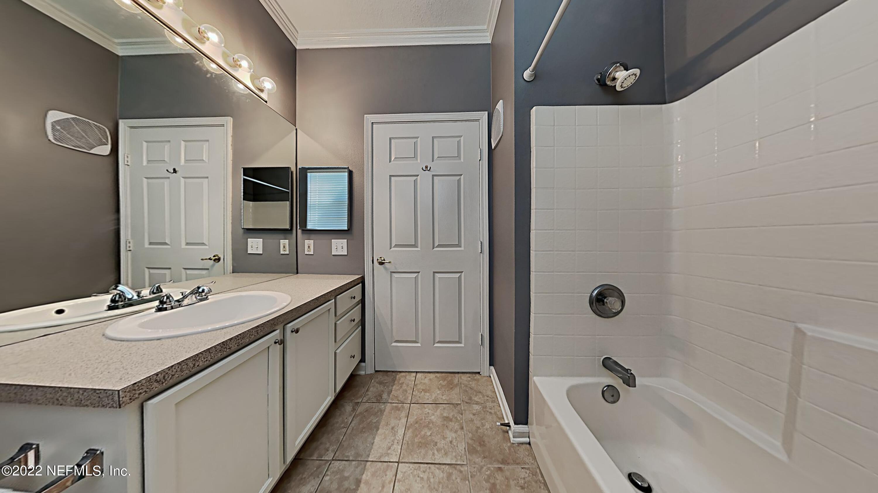 7990 Baymeadows Road, Unit 201 Jacksonville, FL 32256 - Photo 13 of 14 a bathroom with a tub sink double vanity granite tub shower and mirror