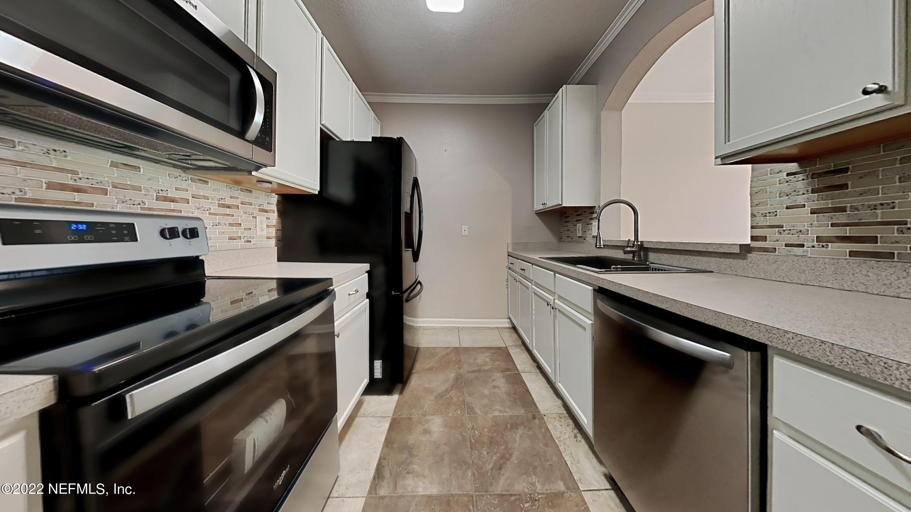 7990 Baymeadows Road, Unit 201 Jacksonville, FL 32256 - Photo 2 of 14 a kitchen with stainless steel appliances a stove a sink and a microwave