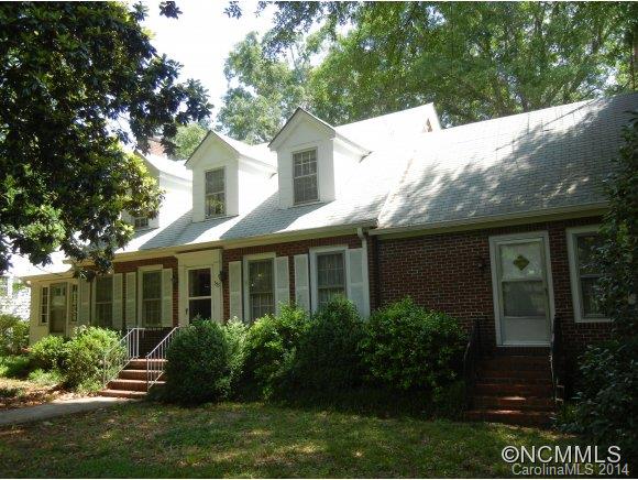 355 South Ridgecrest Street Rutherfordton, NC 28139 - Photo 1 of 24 a view of a white house next to a yard with plants and trees