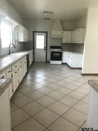 a kitchen with granite countertop a stove a sink and a granite counter tops
