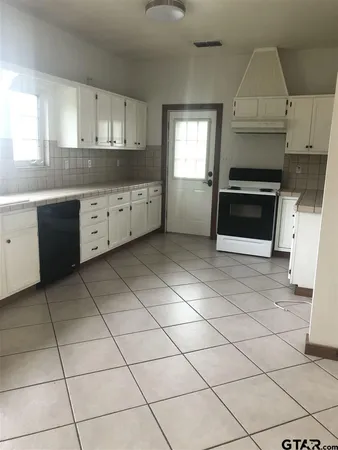 a kitchen with a stove a sink and cabinets