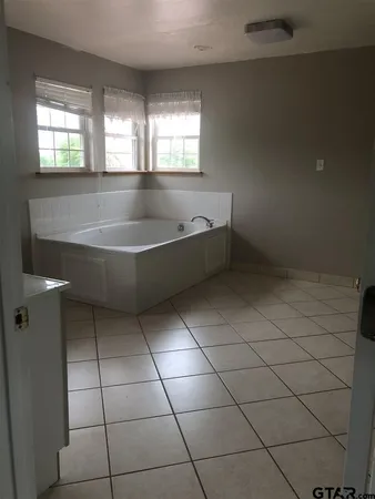 a spacious bathroom with a bathtub and window
