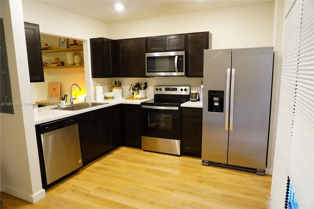 a kitchen with stainless steel appliances a sink cabinets and a refrigerator
