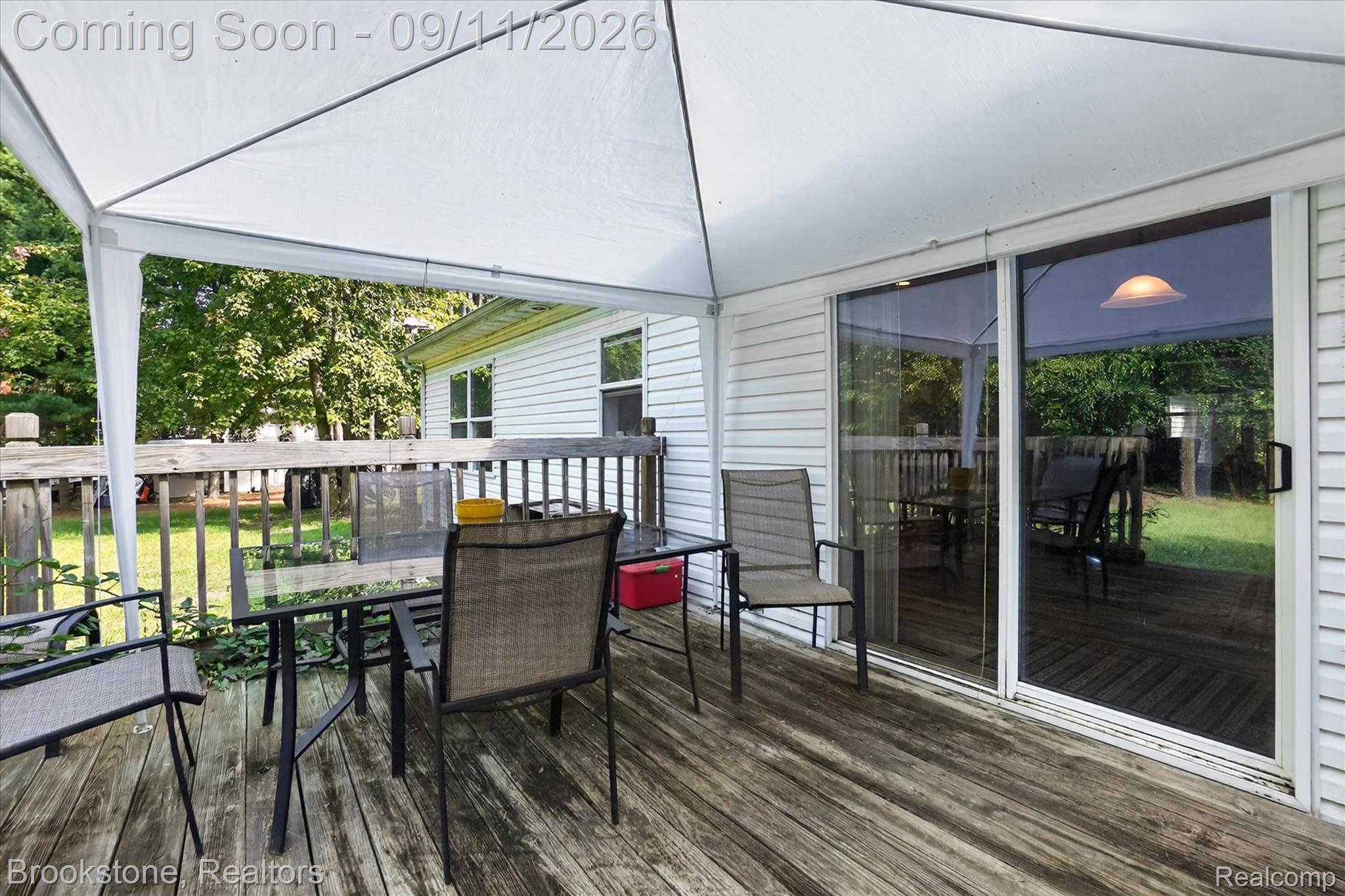 1812 South Steel Road Merrill, MI 48637 - Photo 30 of 39 Outdoor decking with a white canopy, leading to a sliding glass door