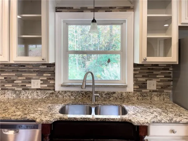 a kitchen with kitchen island granite countertop a sink and a window