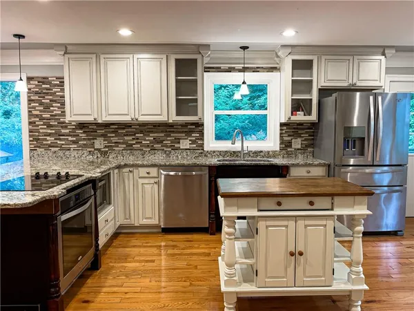 a kitchen with stainless steel appliances granite countertop a stove a sink and a microwave