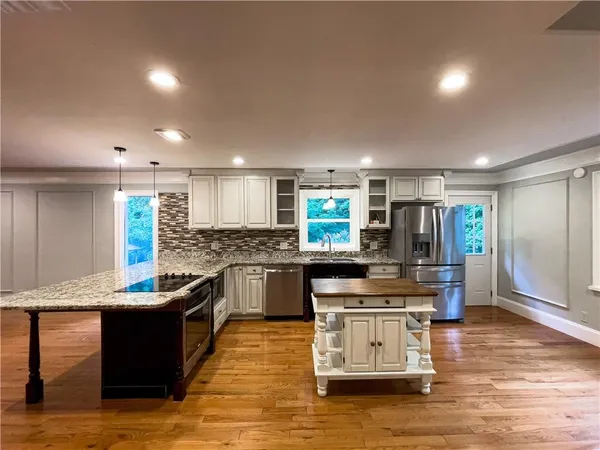 a kitchen with stainless steel appliances kitchen island granite countertop a stove a sink and a refrigerator