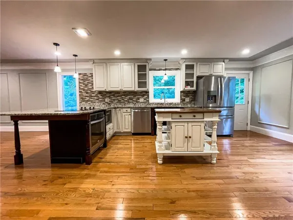 a kitchen with stainless steel appliances kitchen island granite countertop a stove and a sink