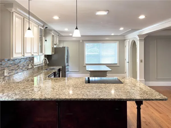 a kitchen with kitchen island granite countertop a sink and counter space