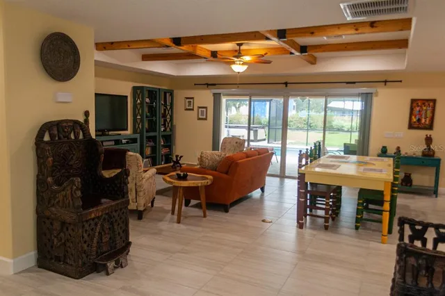a living room with furniture kitchen view and a chandelier
