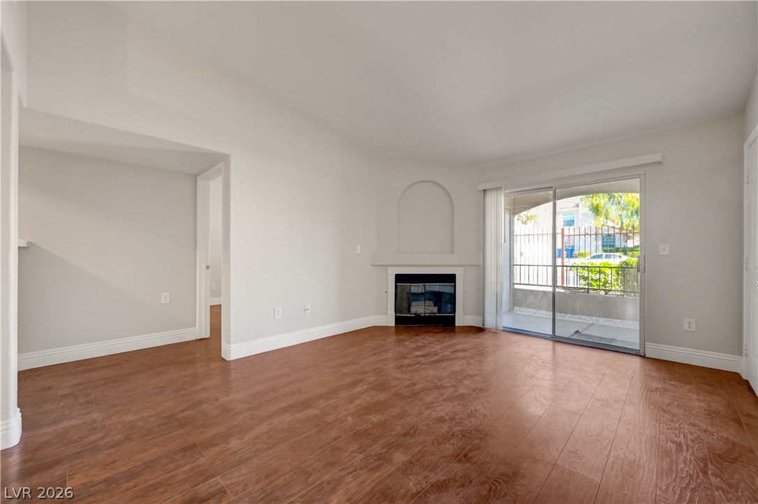 7885 West Flamingo Road, Unit 1050 Las Vegas, NV 89147 - Photo 8 of 62 A refined living space showcasing a cozy fireplace and convenient sliding glass doors leading to outdoor leisure.