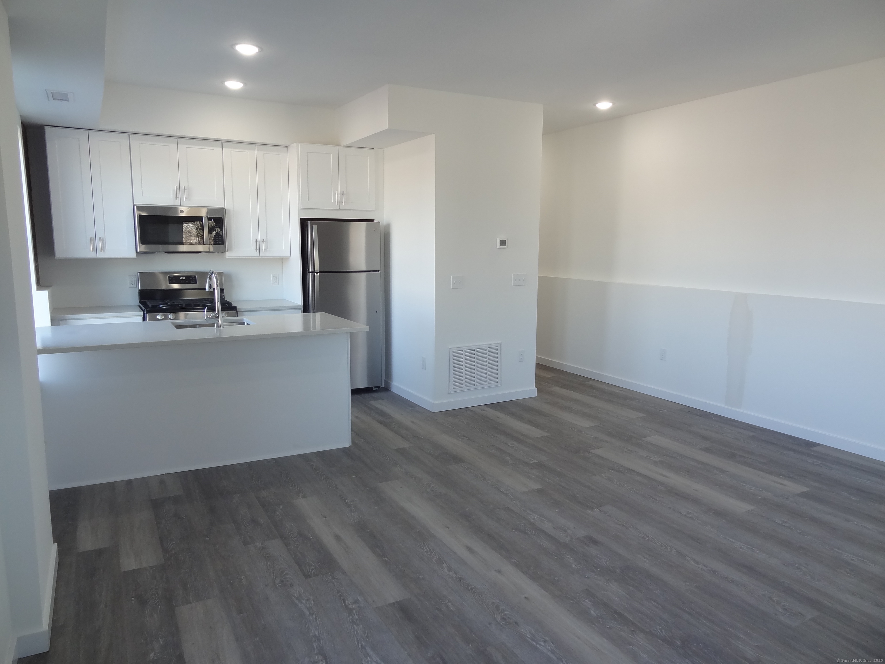 2806 Fairfield Avenue, Unit 101 Bridgeport, CT 06605 - Photo 2 of 25 a kitchen with stainless steel appliances a refrigerator and a stove top oven