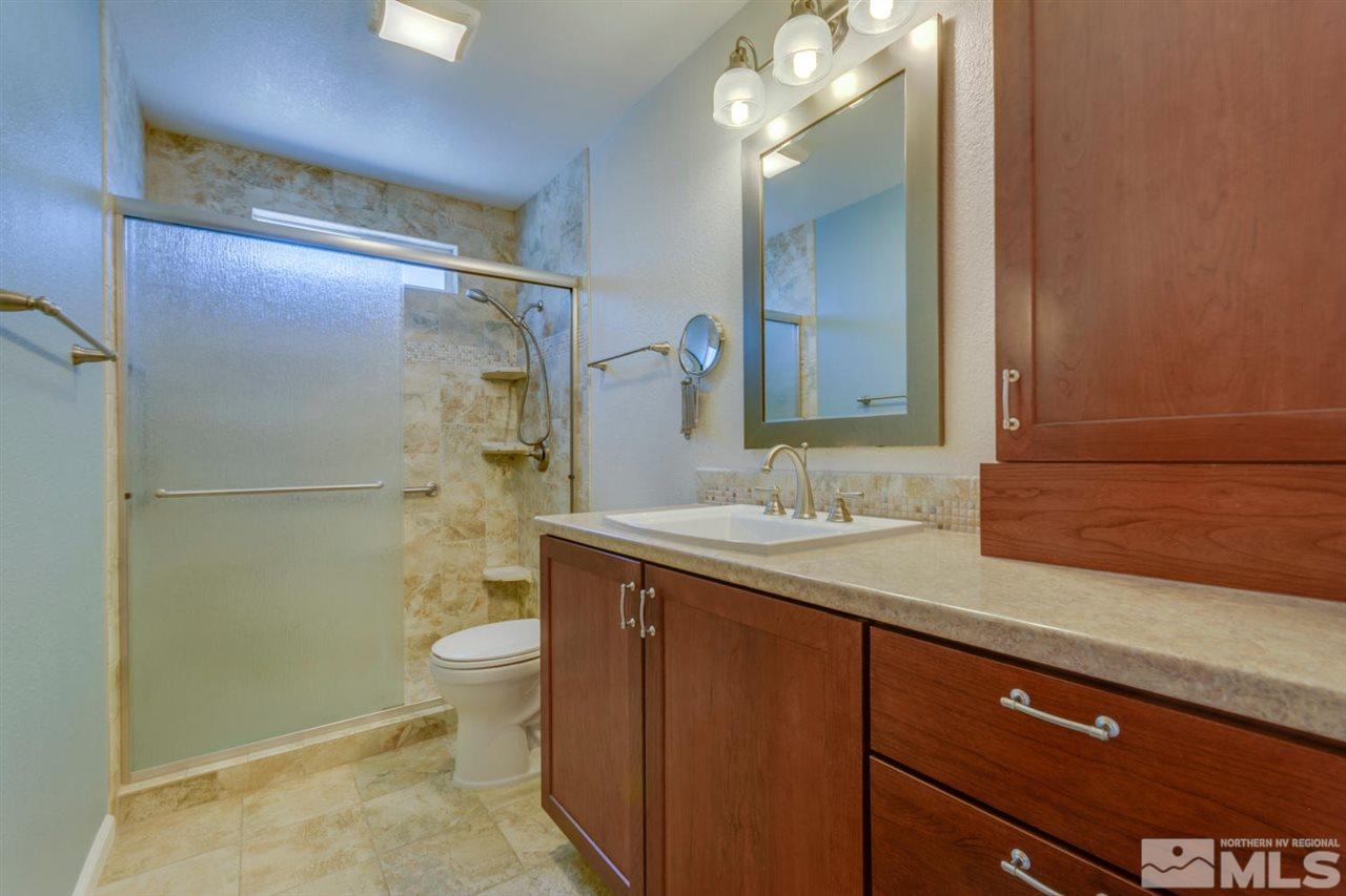 10180 Placerville Road Reno, NV 89508 - Photo 12 of 25 a bathroom with a granite countertop sink toilet and shower