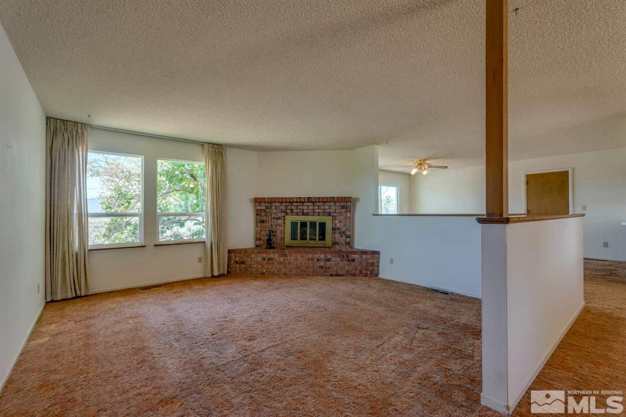 10180 Placerville Road Reno, NV 89508 - Photo 3 of 25 a view of empty room with fireplace and windows
