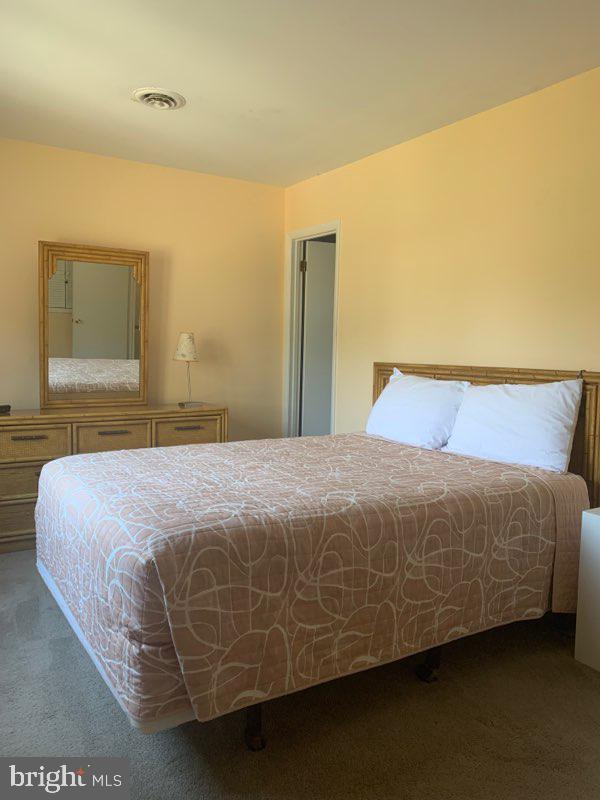 761 Salt Pond Road, Unit A Bethany Beach, DE 19930 - Photo 11 of 16 a bedroom with a bed and a painting on the wall