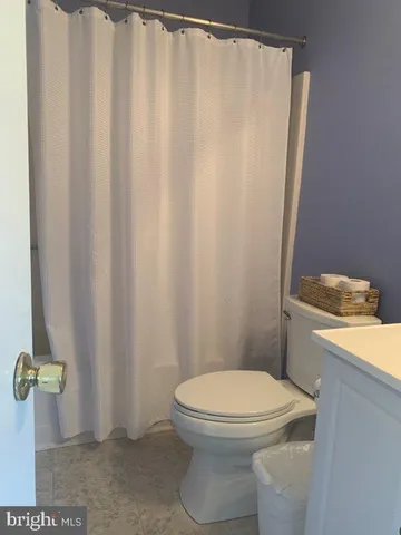 a white toilet sitting next to a shower curtain