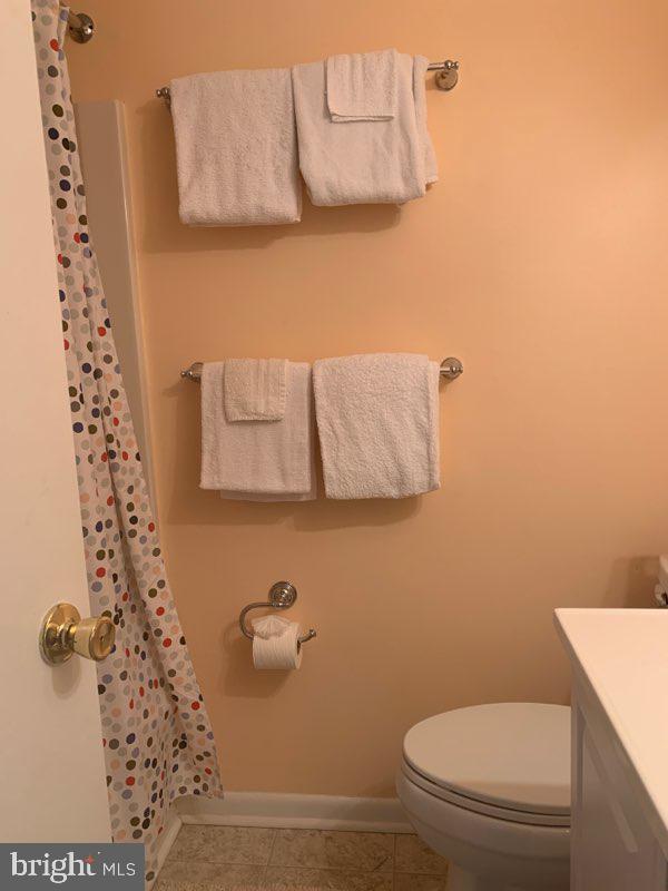761 Salt Pond Road, Unit A Bethany Beach, DE 19930 - Photo 14 of 16 a bathroom with a toilet and a shower curtain
