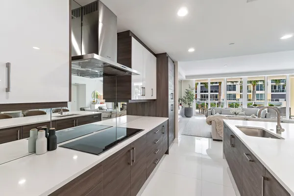 a large kitchen with stainless steel appliances a large counter top a stove a chimney a sink and a large window