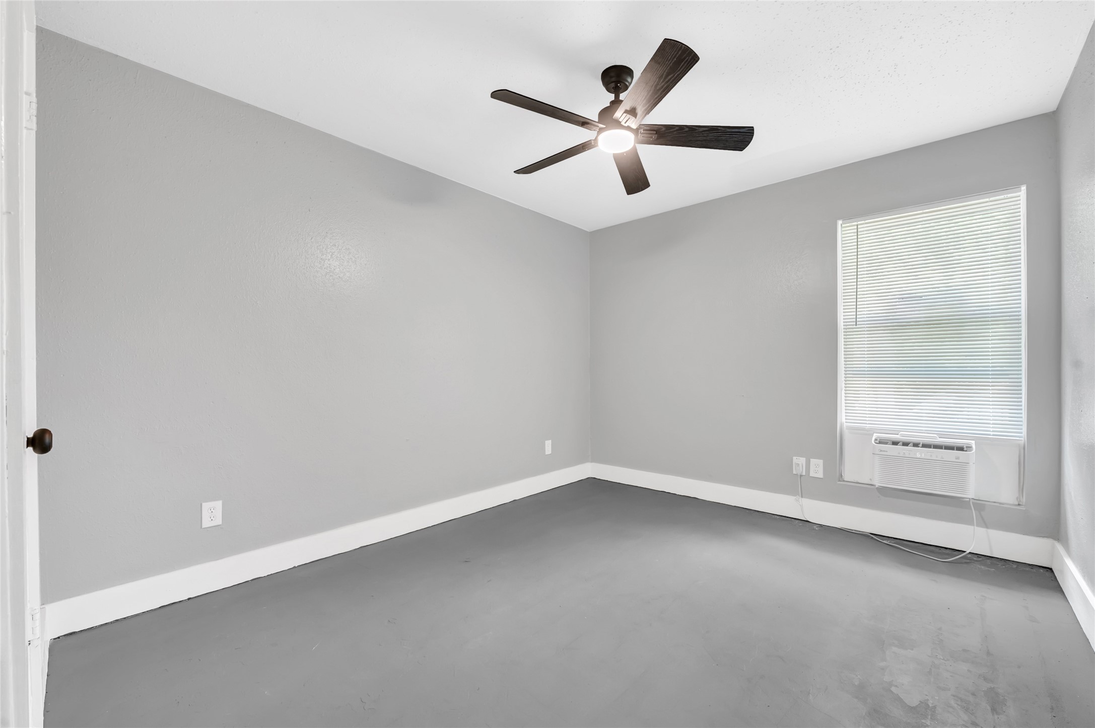 3802 Dabney Street, Unit 15 Houston, TX 77026 - Photo 6 of 13 an empty room with ceiling fan and window