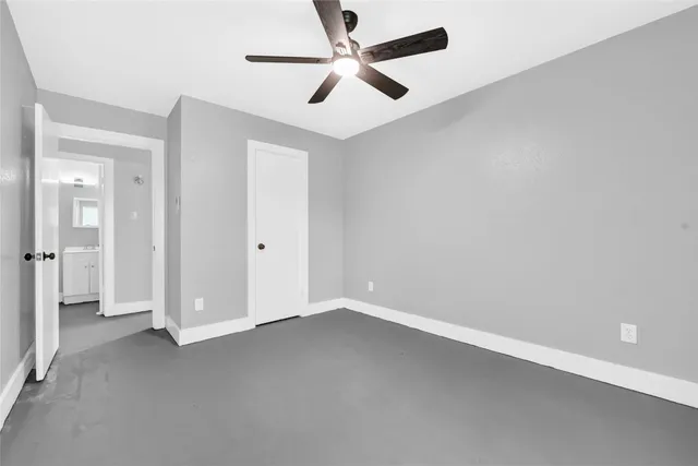 an empty room with closet and windows