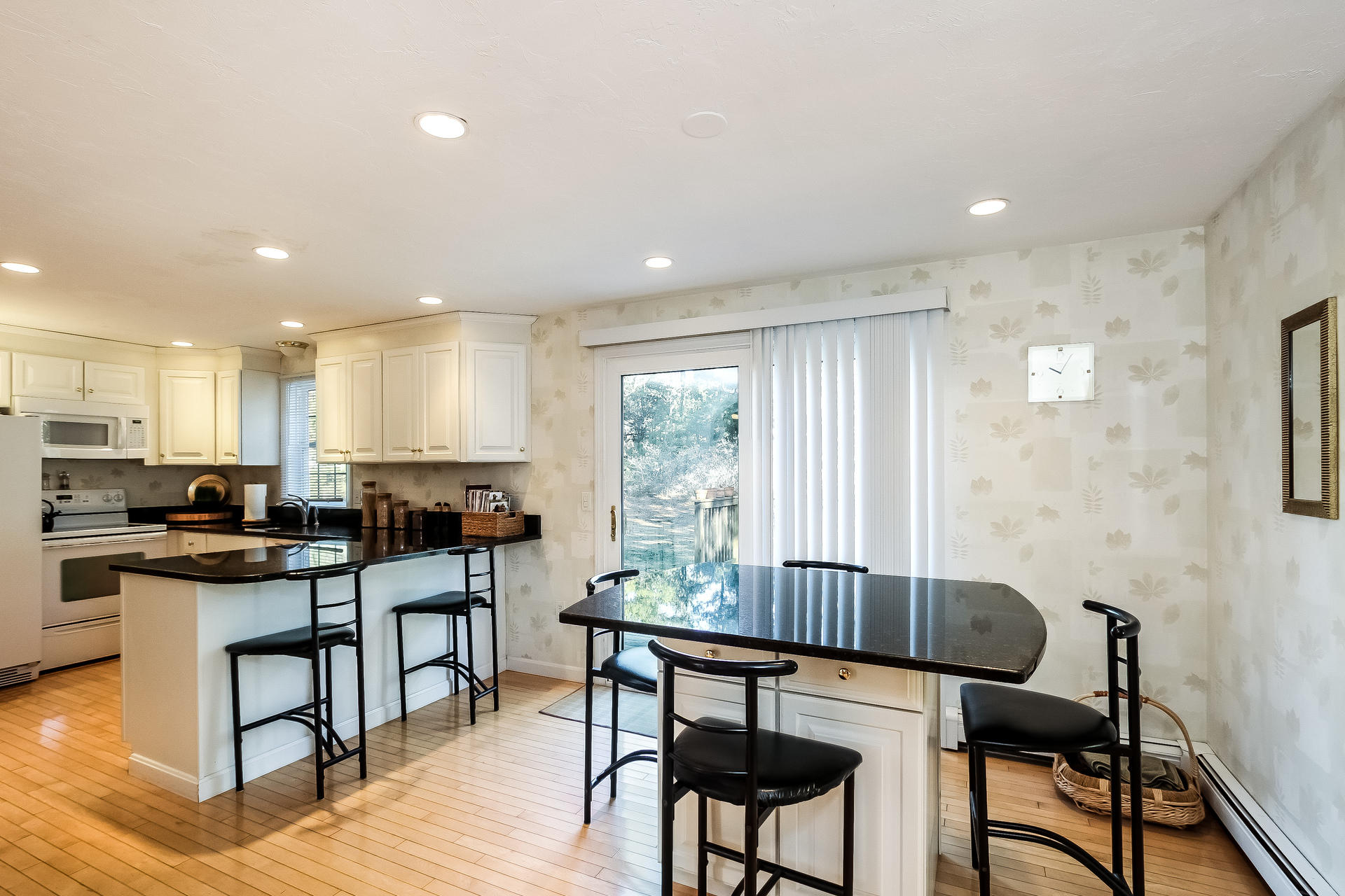 9 Wintergreen Road Mashpee, MA 02649 - Photo 3 of 24 a kitchen with stainless steel appliances granite countertop a stove a sink a refrigerator white cabinets with chairs and dining table