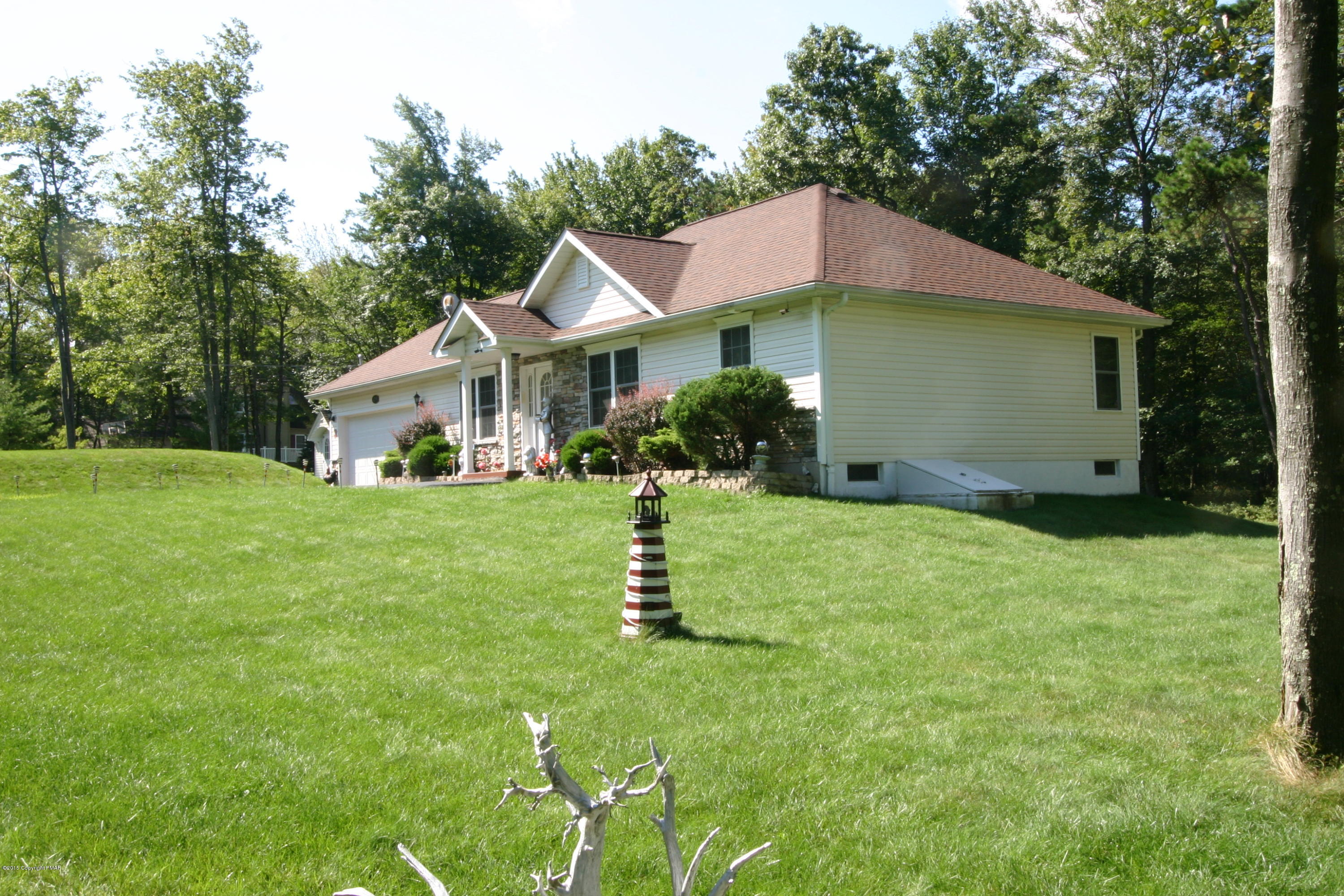 6293 Laurel Road Pocono Summit, PA 18346 - Photo 4 of 32 a front view of a house with a yard and garage
