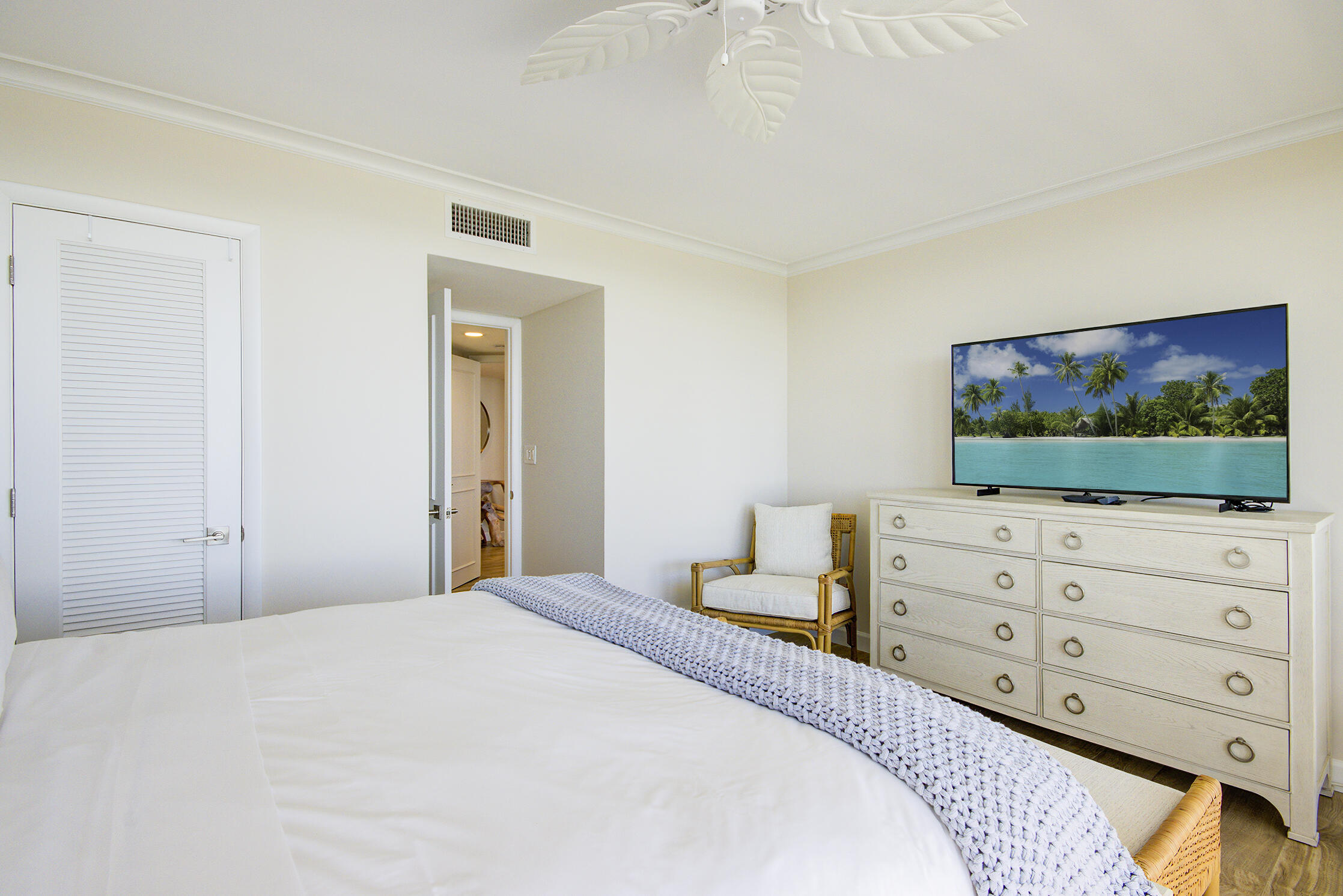 120 South Ocean Boulevard, Unit 4A Delray Beach, FL 33483 - Photo 11 of 36 a bedroom with a bed and a flat screen tv in white walls