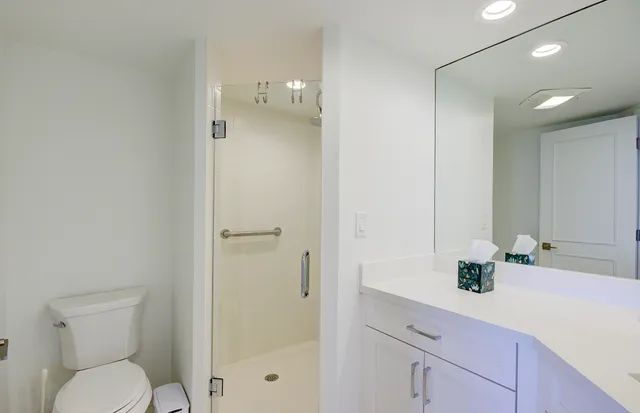 a bathroom with double vanity sinks a mirror and a shower