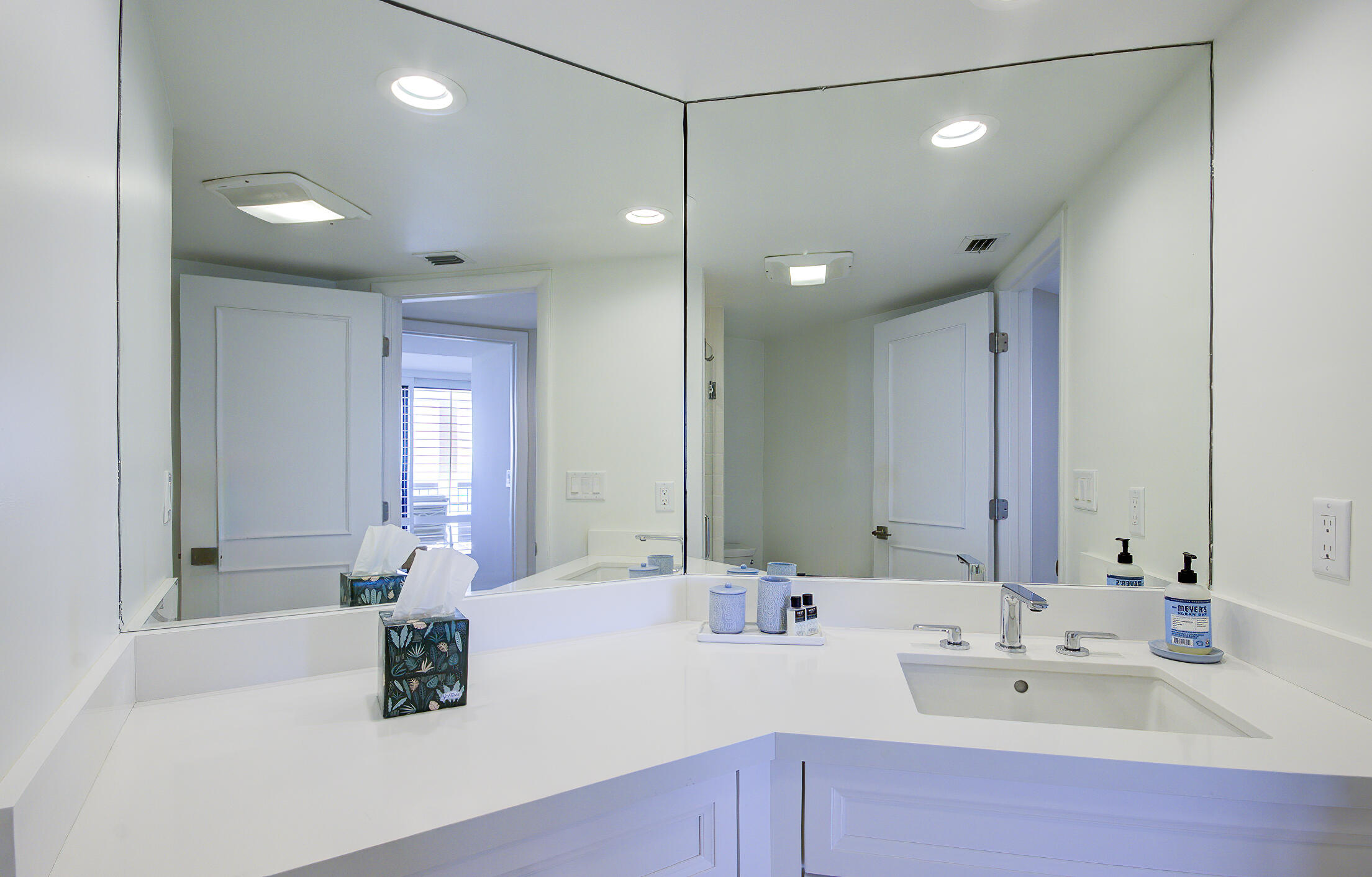 120 South Ocean Boulevard, Unit 4A Delray Beach, FL 33483 - Photo 13 of 36 a bathroom with double vanity sinks a mirror and a shower
