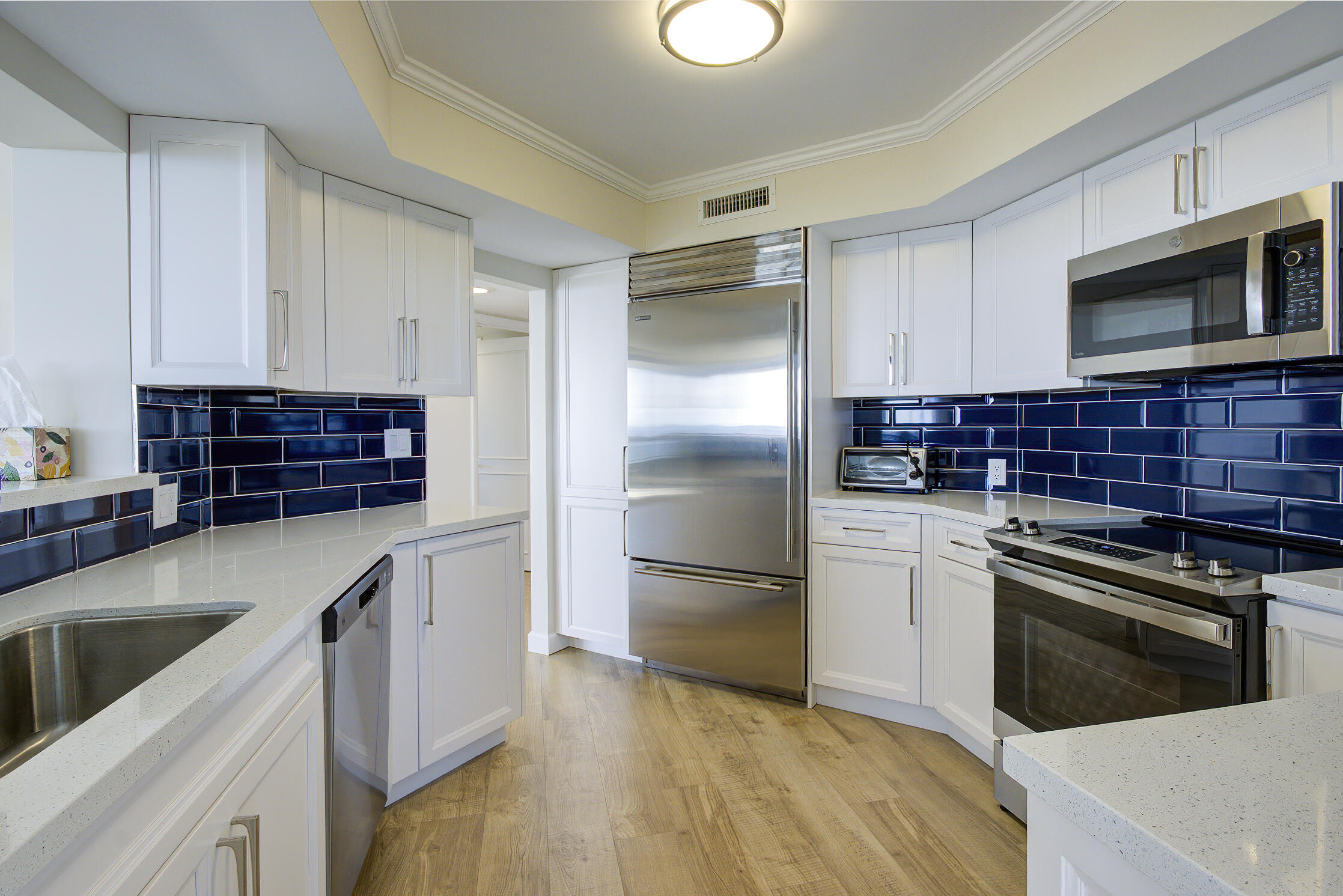 120 South Ocean Boulevard, Unit 4A Delray Beach, FL 33483 - Photo 8 of 36 a kitchen with granite countertop stainless steel appliances and wooden cabinets