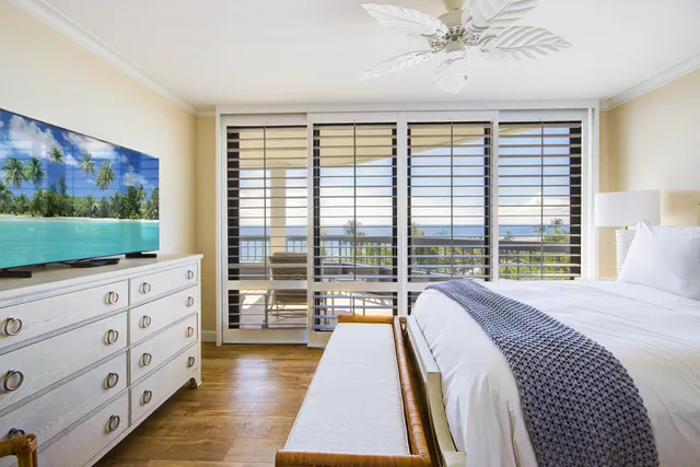 a bedroom with a bed and a flat screen tv in white walls