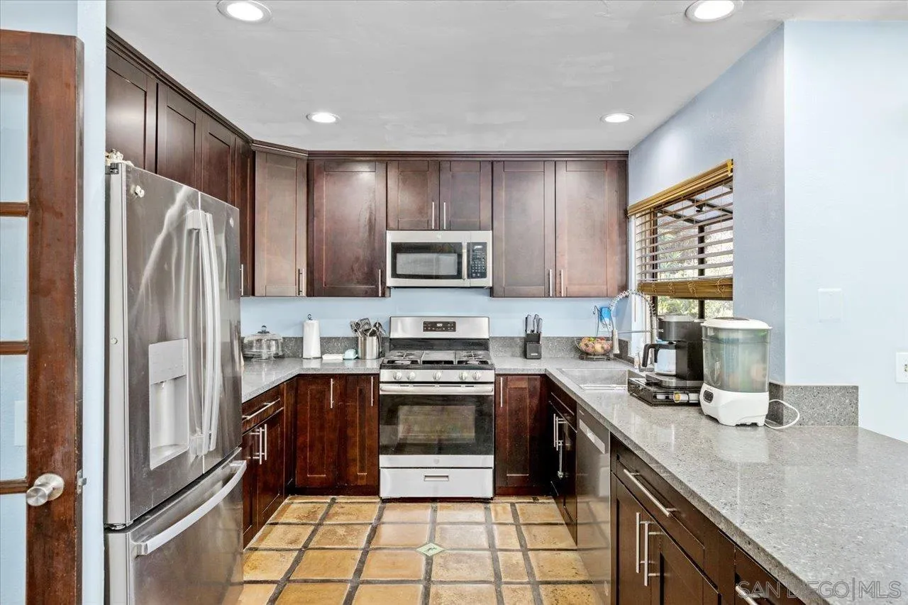 2337 Fallingleaf Road Oceanside, CA 92056 - Photo 7 of 34 a kitchen with stainless steel appliances granite countertop a stove top oven a sink and a refrigerator