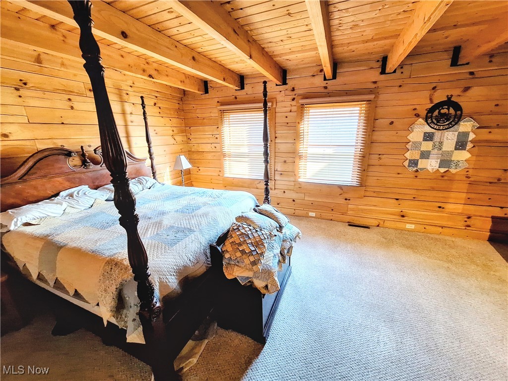 587 North Fork Road Wheeling, WV 26003 - Photo 23 of 35 Carpeted bedroom featuring beamed ceiling, wood walls, and wood ceiling