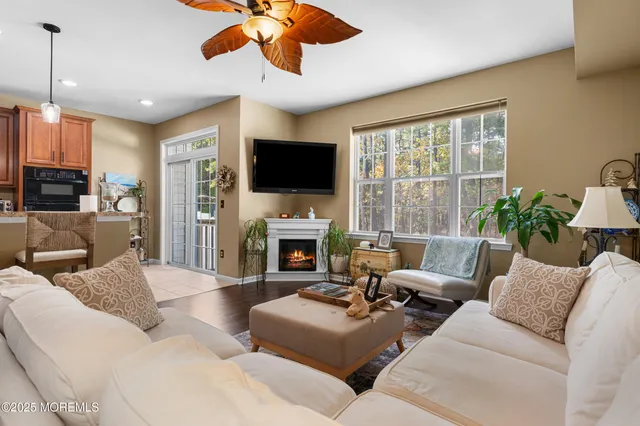 a kitchen with stainless steel appliances granite countertop a stove a sink a microwave a dining table and chairs with wooden floor