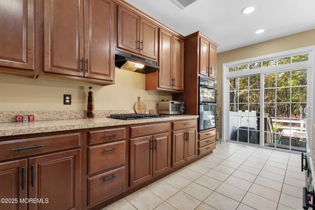 a open kitchen with stainless steel appliances granite countertop a stove a sink and a refrigerator