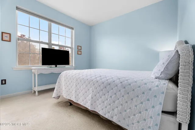 a bedroom with a bed and a flat tv screen on the dresser