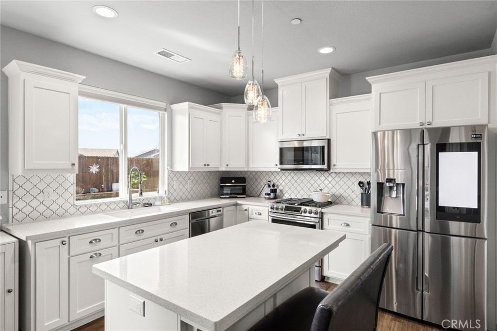 3465 Shaker Lane Chico, CA 95973 - Photo 8 of 34 a kitchen with a refrigerator a stove a sink and white cabinets