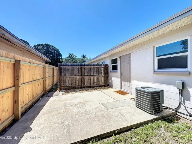 a backyard of a house with wooden floor outdoor seating and yard in the back