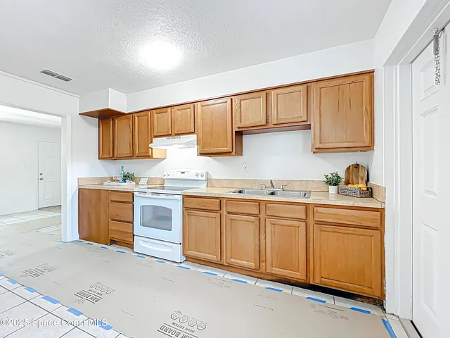 a kitchen with granite countertop a sink stainless steel appliances and cabinets