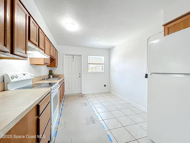 a kitchen with a stove a sink and a refrigerator