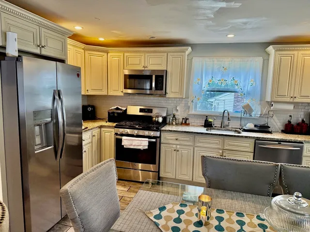 a living room with furniture a table and kitchen view