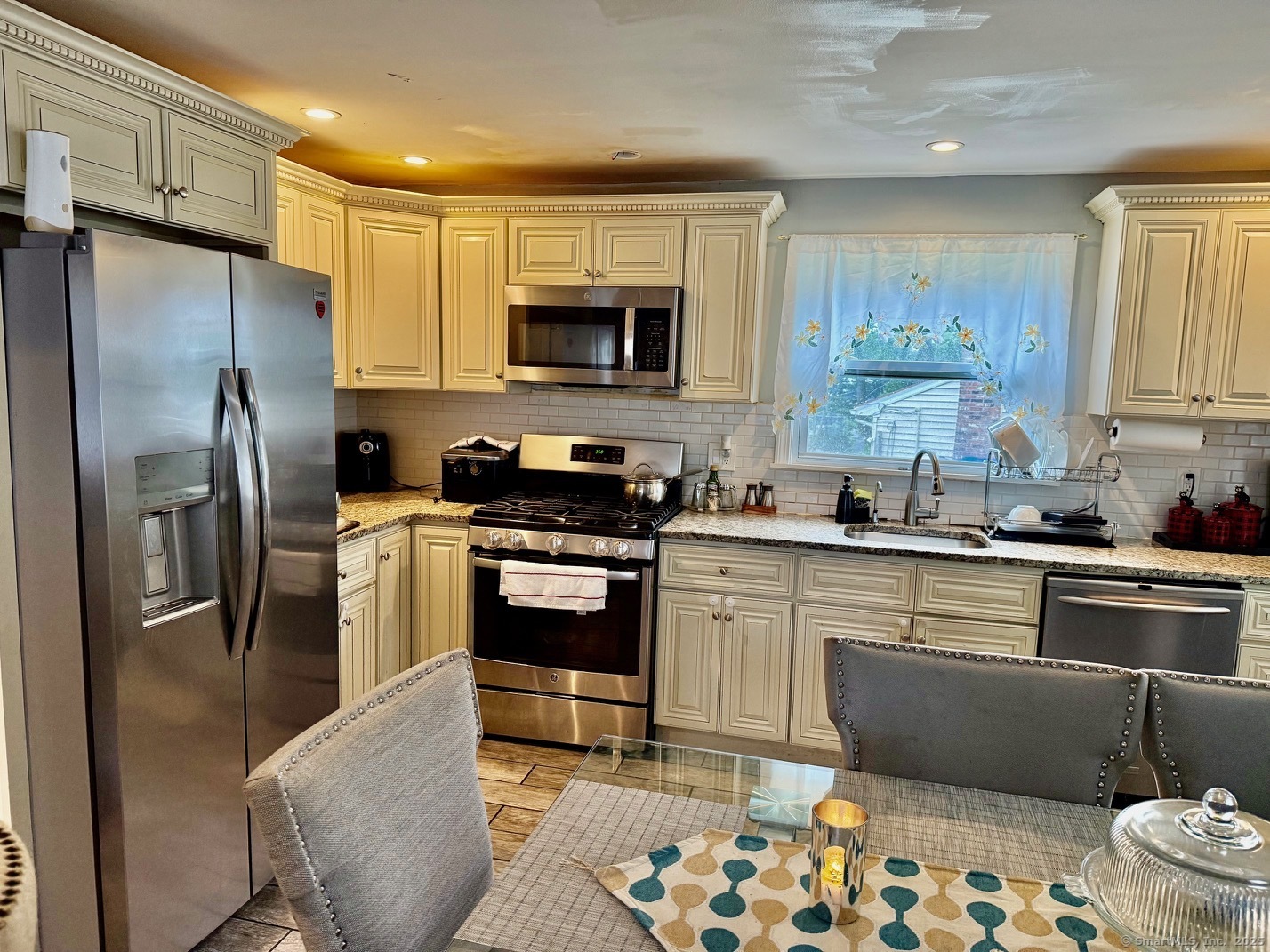 15 Edwards Street Bridgeport, CT 06606 - Photo 16 of 33 a kitchen with stainless steel appliances granite countertop a refrigerator a stove a sink a dining table and chairs