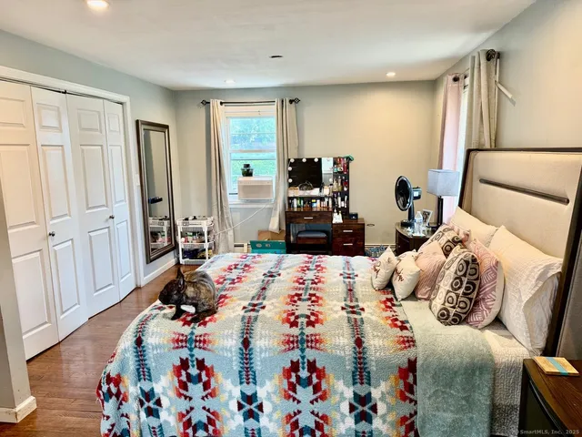 a bedroom with a bed and wooden floor