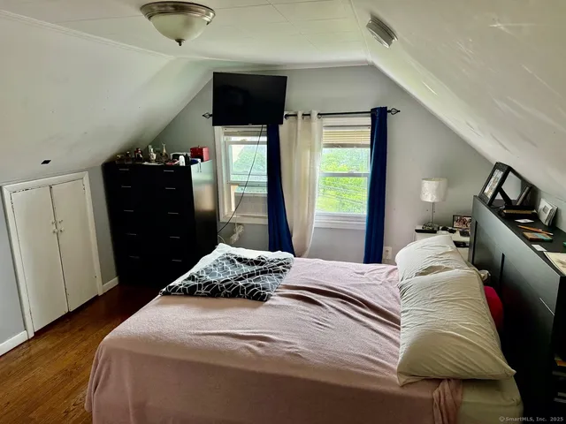 a bedroom with a bed and a flat tv screen